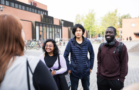 Students outside of campus, smiling 