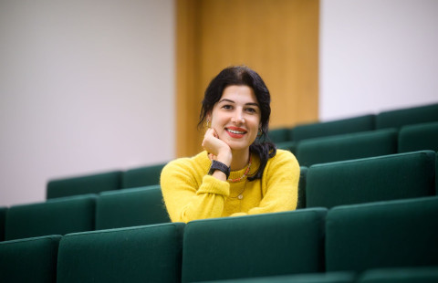 Student sitting in lecture and smiling