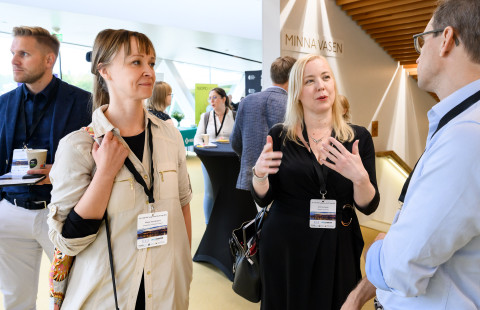 Merja Heinäniemi keskustelee kahden henkilön kanssa.