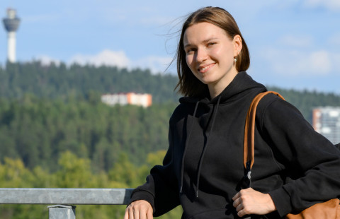 UEF-lähettiläs Tia Saharinen taustallaan kesäinen maisema ja Puijon torni