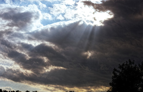Auringon säteet pilvien takaa.
