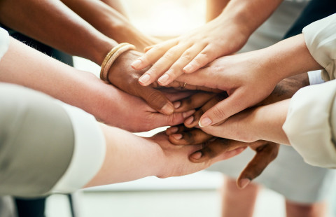 Päällekkäin oleviä käsiä.