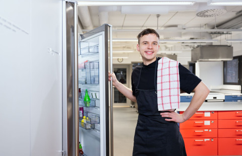 Kotitalousopettajaopiskelija jääkaapilla opetuskeittiössä