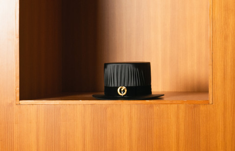 Tohtorihattu puisella hyllyllä.