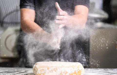 Pastry chef clapping his hands with flour while making dough. Photo Mostphotos.