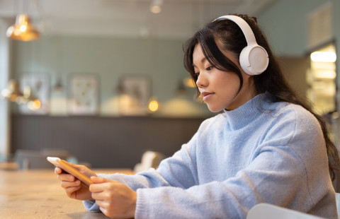 A person using Celia services with their smartphone and headphones.