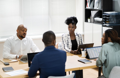 Neljä henkilöä kokouksessa.