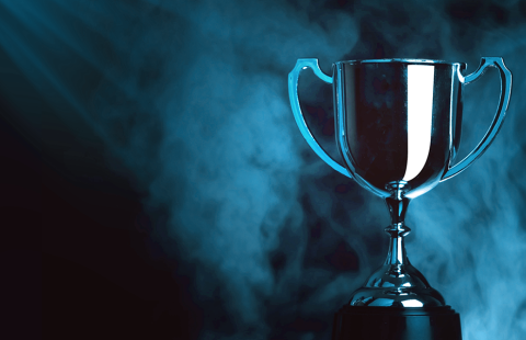 Tummalla taustalla siniset valot kohdistuvat pokaaliin