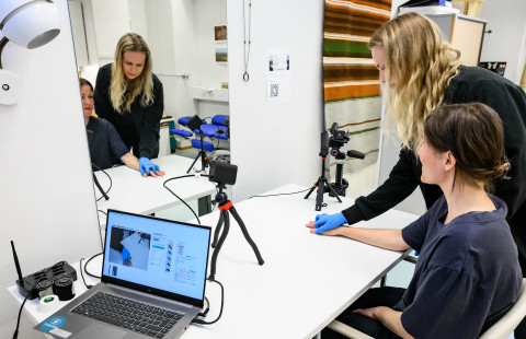 Fysioterapeutti auttaa potilasta harjoittamaan käsivarren lihaksia.