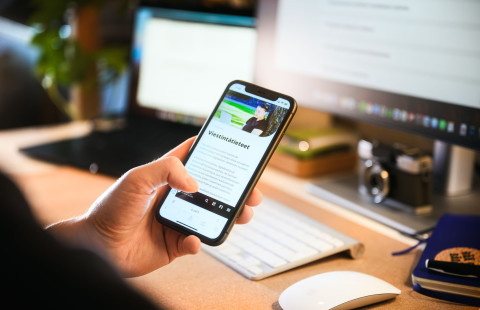 Henkilö selaamassa verkkosivuja puhelimella.