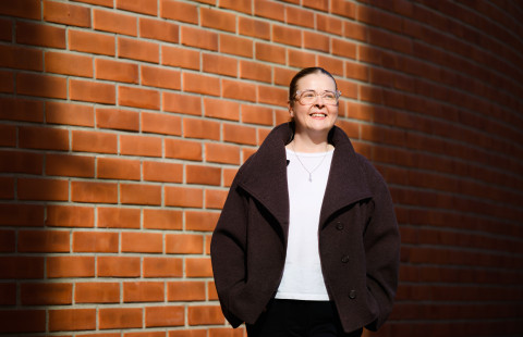 Opiskelija Tea Salo kampusrakennuksen seinustalla