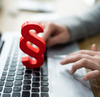 Punainen lakipykälä-merkki kannettavan tietokoneen näppäimistön päällä