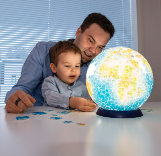 Aikuinen ja lapsi kokoavat maapallopalapeliä.