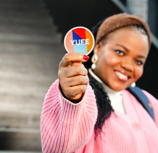 Henkilö pitää YUFE-merkkiä kädessään.