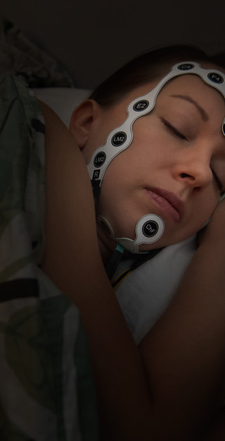 Sleeping person wearing a screen-printed emergency EEG electrode set developed for at-home assessment of sleep bruxism