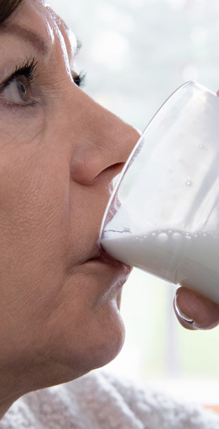 Nainen juo maitotuotetta