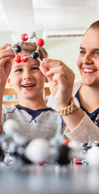Äiti ja lapsi rakentamassa molekyylimalleja.