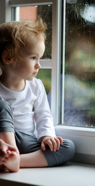 Lapsi katsoo ulos ikkunasta