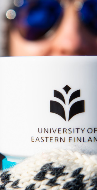 Woman holding a UEF mug.