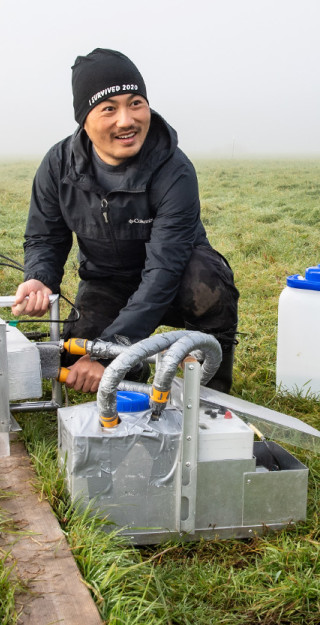 Zheng Yu taking measurements on peatland field.