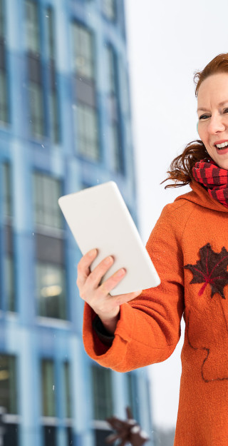 JO brändikuva nainen kuuntelee luentoa tai on taoaamisessa tabletilla työpaikan edessä