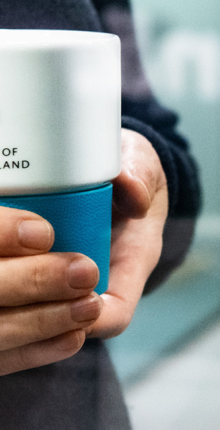 Hands holding a mug.