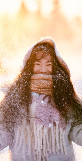Student standing in snow and smiling